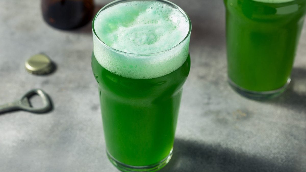 Zwei Gläser Green Beer auf einem grauen Untergrund.