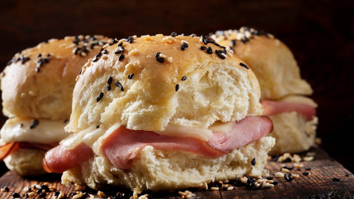 seitliche Nahaufnahme von den Käse-Schinken-Sliders mit schwarzem Hintergrund