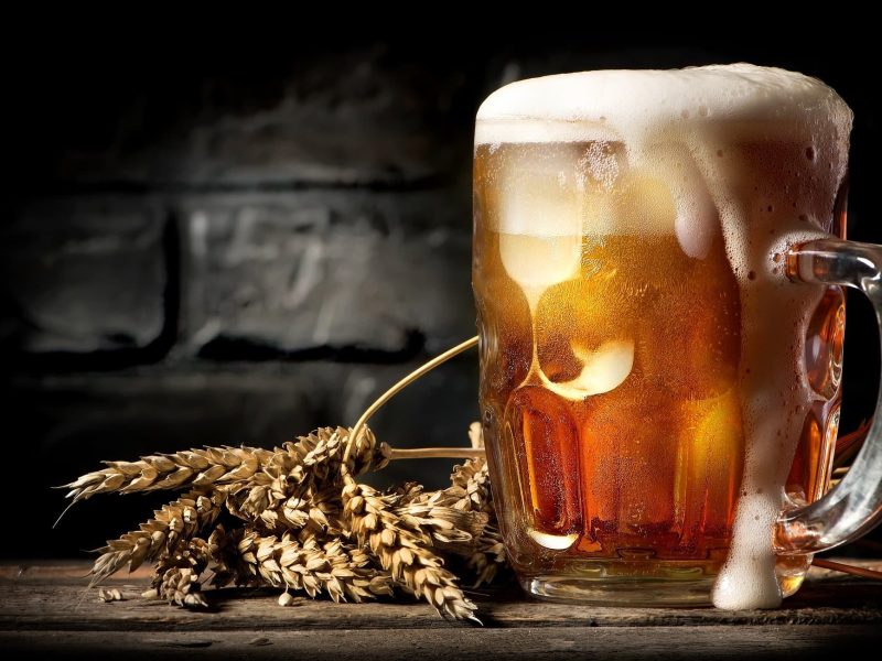 Ein üppig gefülltes, überschäumendes Henkelglas mit Bier.