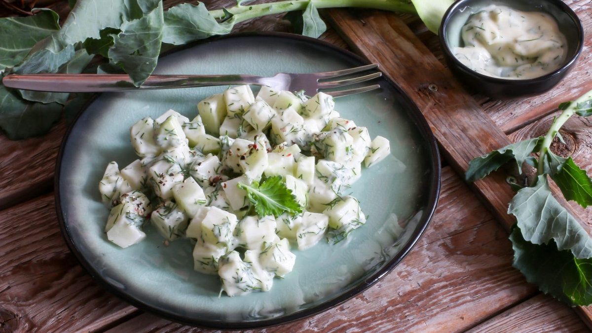 Auf einem Teller liegt ein angerichteter Kohlrabi-Salat mit einem Joghurt-Dressing