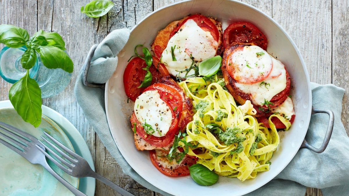 Unsere Minutensteaks Caprese angerichtet mit Bandnudeln in einer Pfanne.