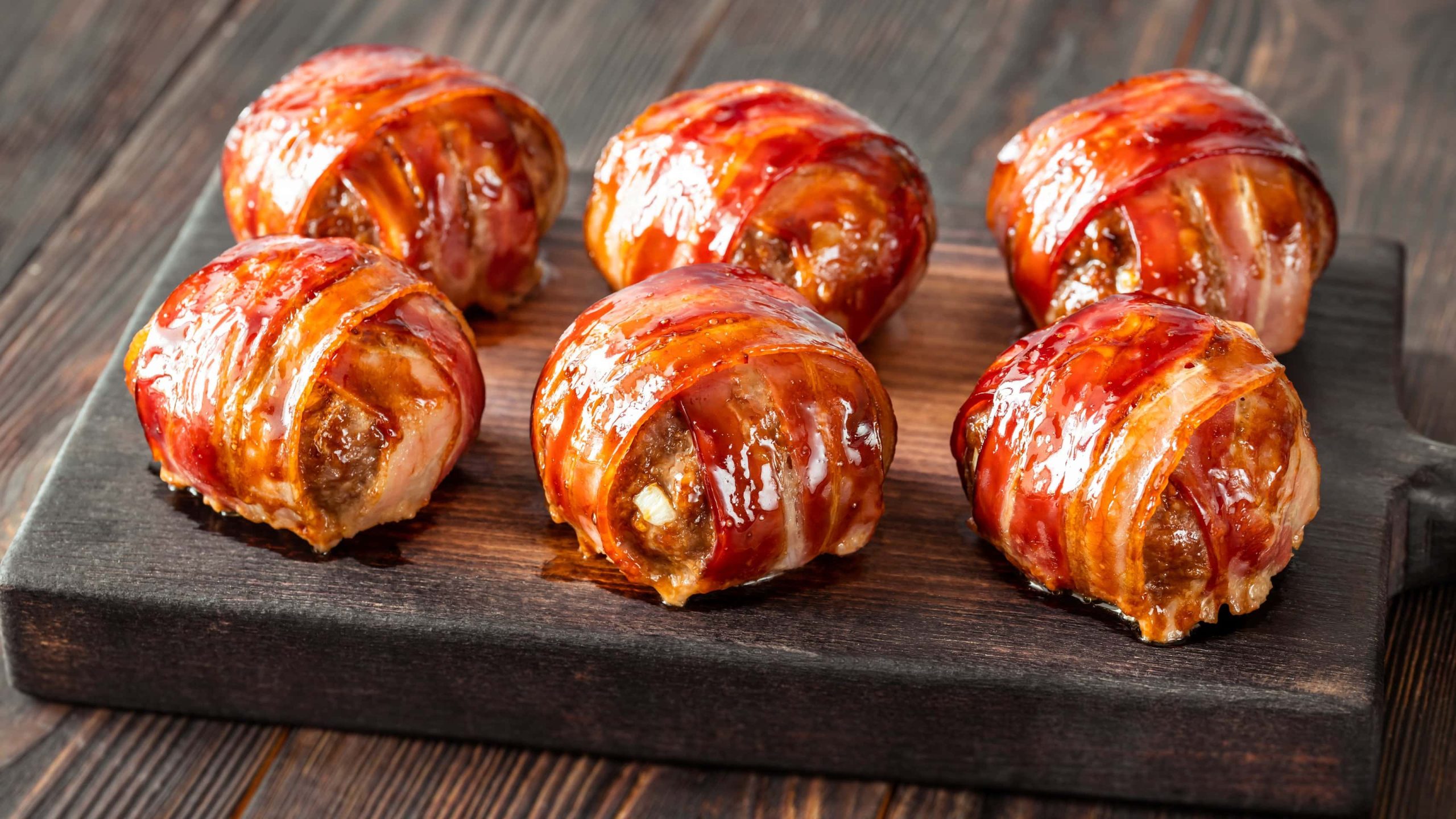moink balls von schräg oben auf schwarzem brett auf holztisch