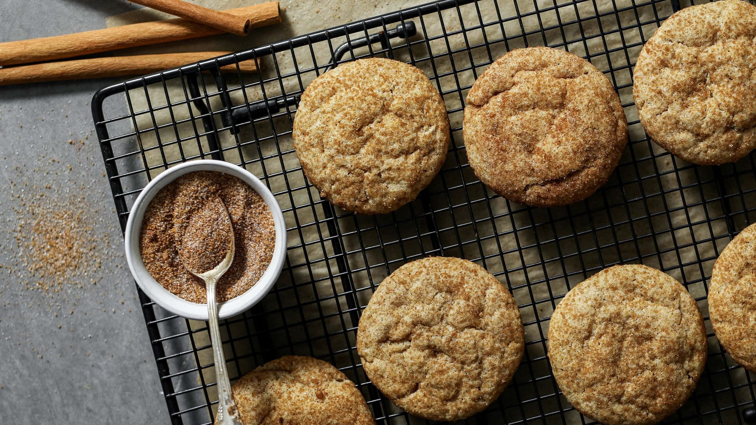 Snickerdoodles von oben auf einem Gitter mit Zimtstangen und Zimt und Zucker