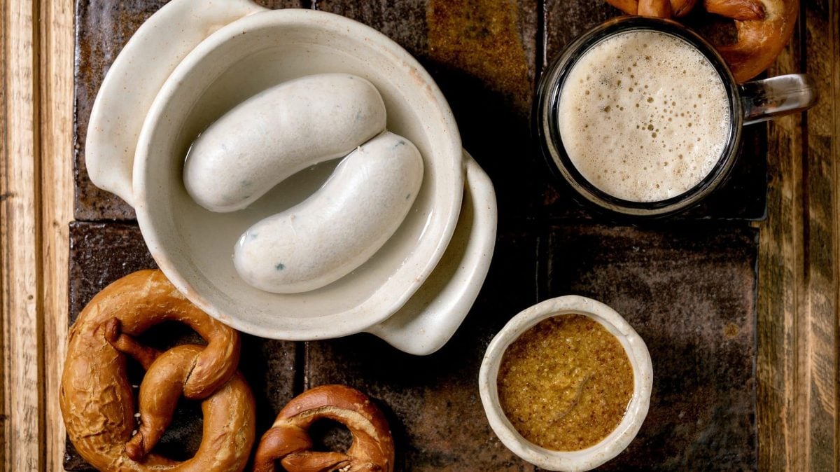 Aus der Vogelperspektive: Ein bayerisches Weißwurstfrühstück: Es gib Brezen, süßen Senf, Weißwurst und ein Bier.