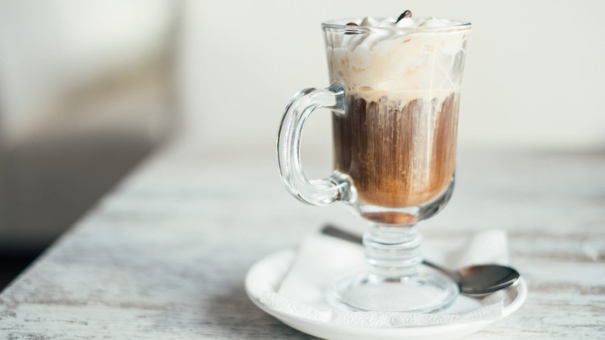 Irish Coffee mit Sahne in gläserner Tasse.