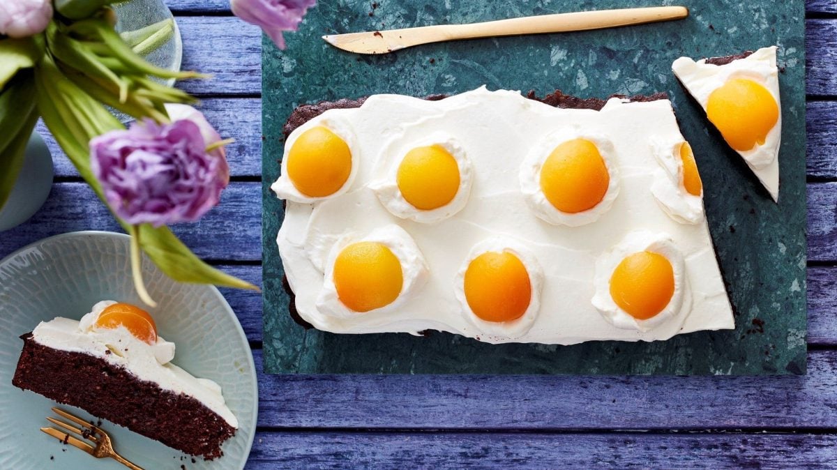 Angeschnitten steht sie auf einem marmorierten Untergrund: unsere Spiegelei-Brownie-Tarte.
