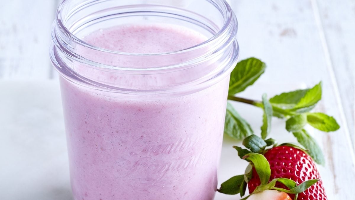 Erdbeer-Kefir-Shake einem Glas neben frischen Erdbeeren