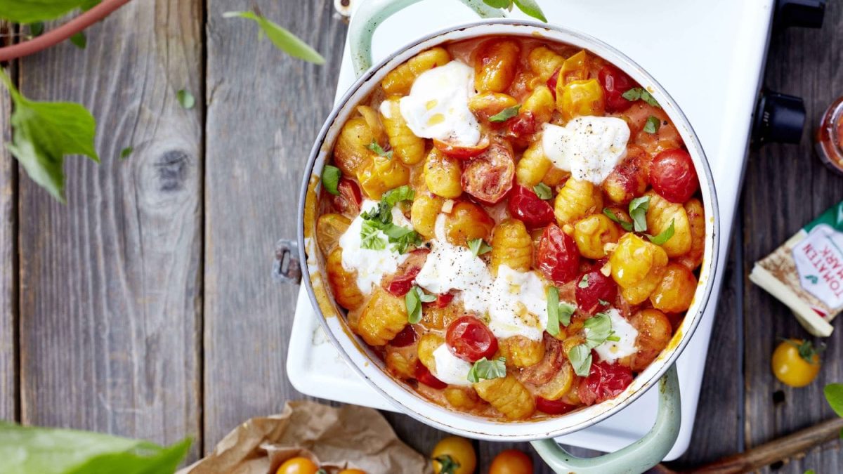 Gnocchi mit geschmolzenem Käse in Tomatensauce in einem Topf