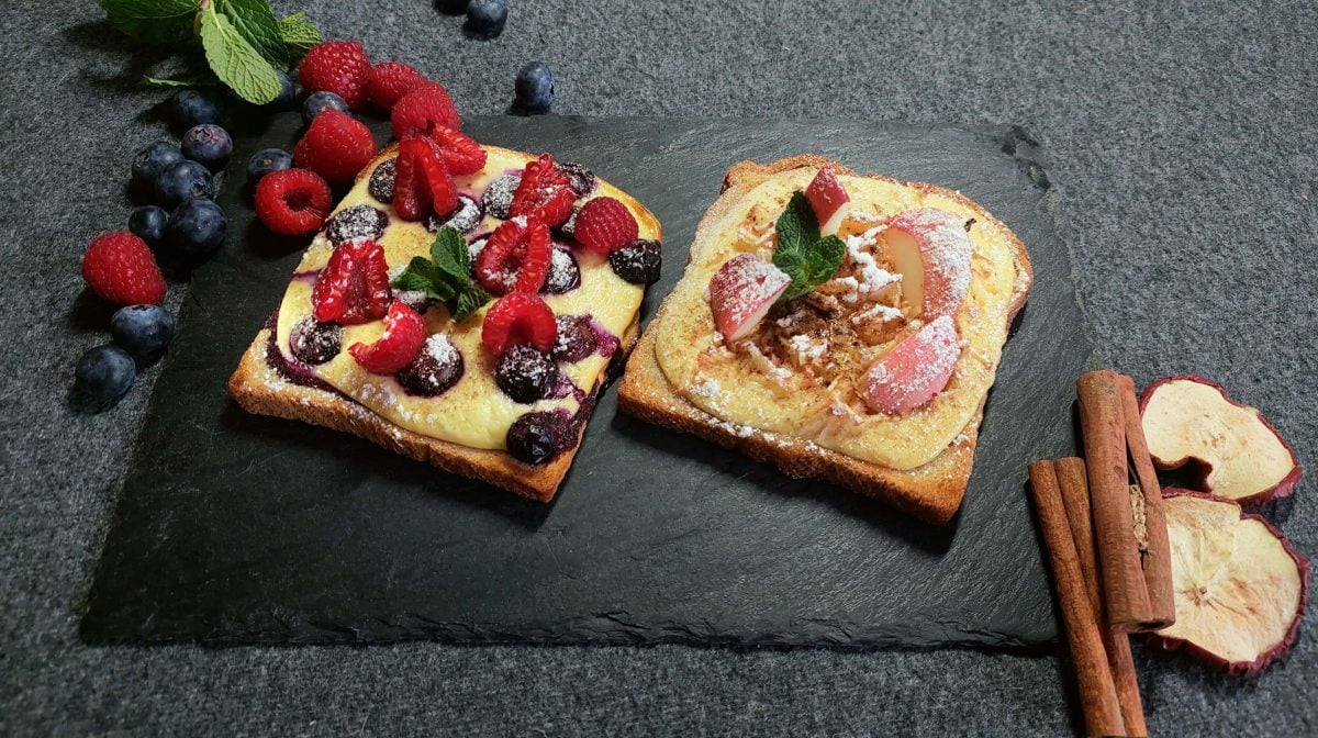 Toasts von oben mit Früchten auf schwarzer Schieferplatte