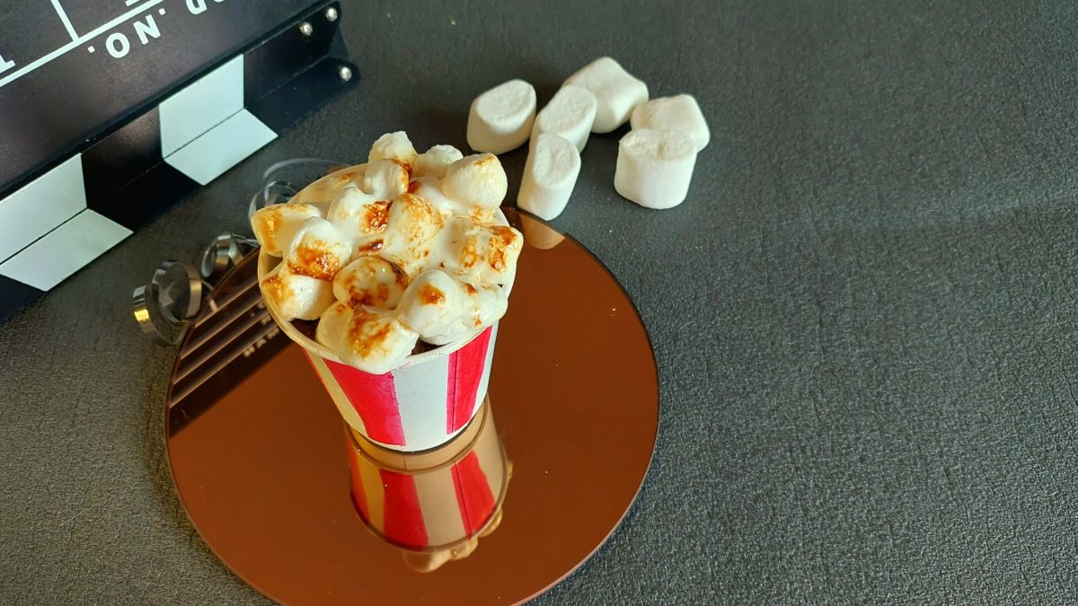 Ein gebackener Muffin mit karamellisierten Marshmallows on top auf grauem Untergrund.