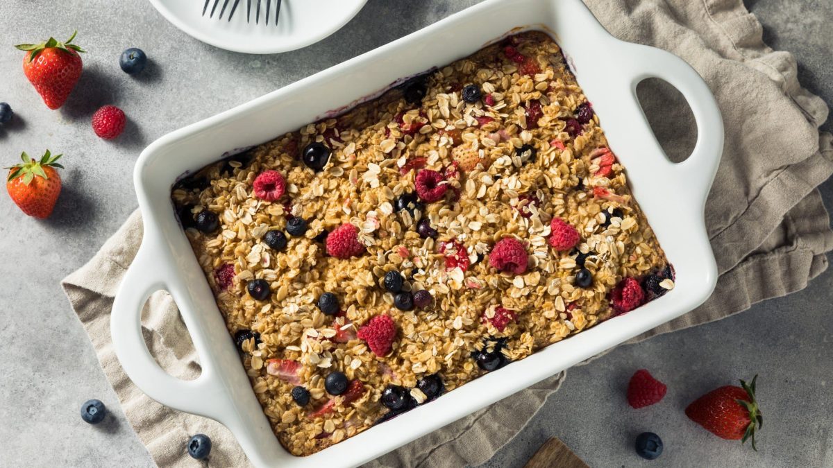 Ein Haferflocken-Auflauf auf einem weißem Tisch mit Beeren.