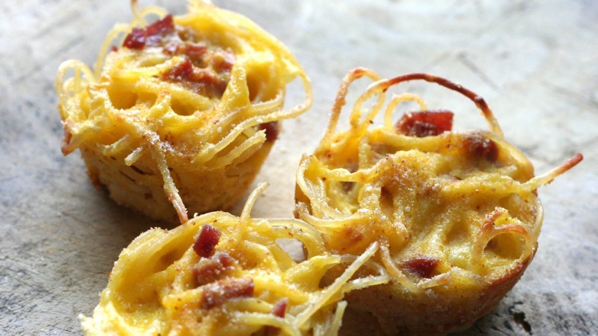 Drei kleine gratinierte Pasta Frittata auf grauem Untergrund