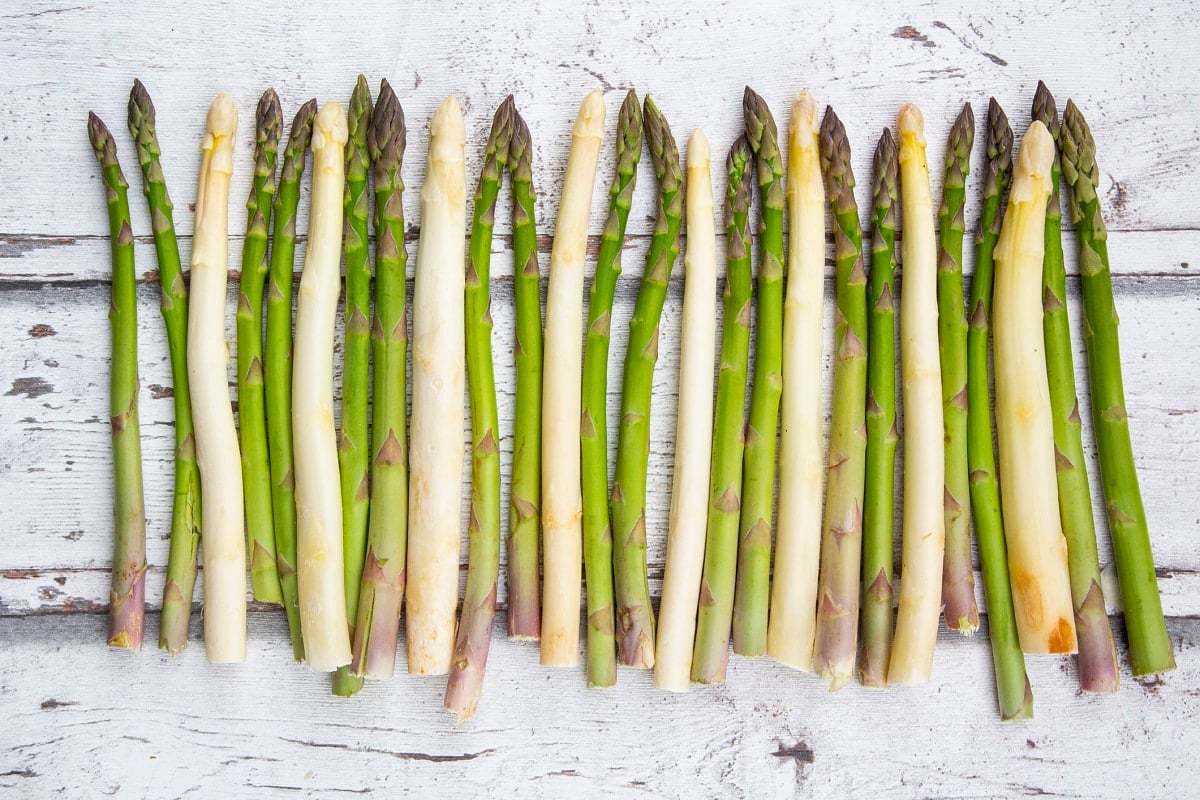 Weißer und grüner Spargel auf einem Brett aufgereiht