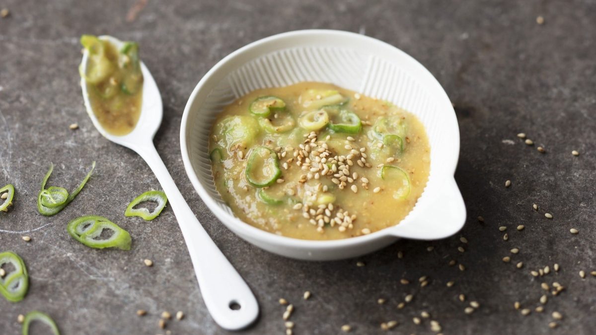 Würziger Miso-Dip mit Frühlingszwiebeln und Sesam und japanischen Gewürzen auf einem steinernen Tisch.