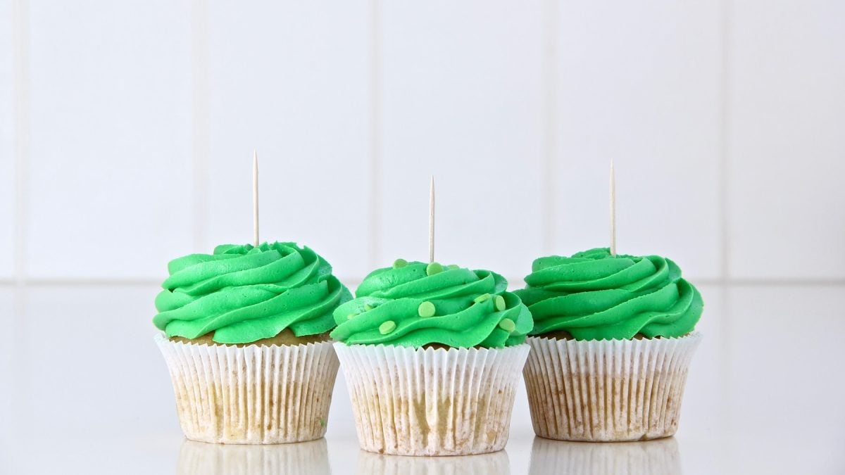 3 vegane Schoko-Muffins mit Minze vor weißen Fließen in hellem Setting.