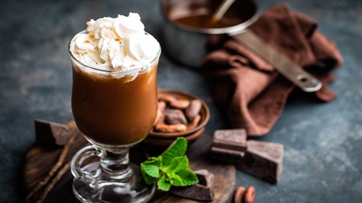 Glas mit Eisschokolade und Schlagsahne auf dunklem Untergrund.