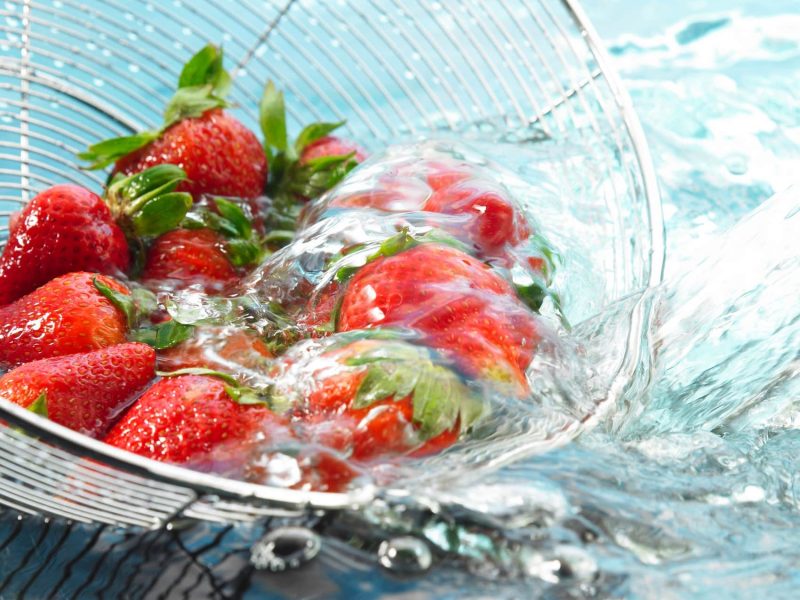 Erdbeeren werden in einem Sieb gewaschen