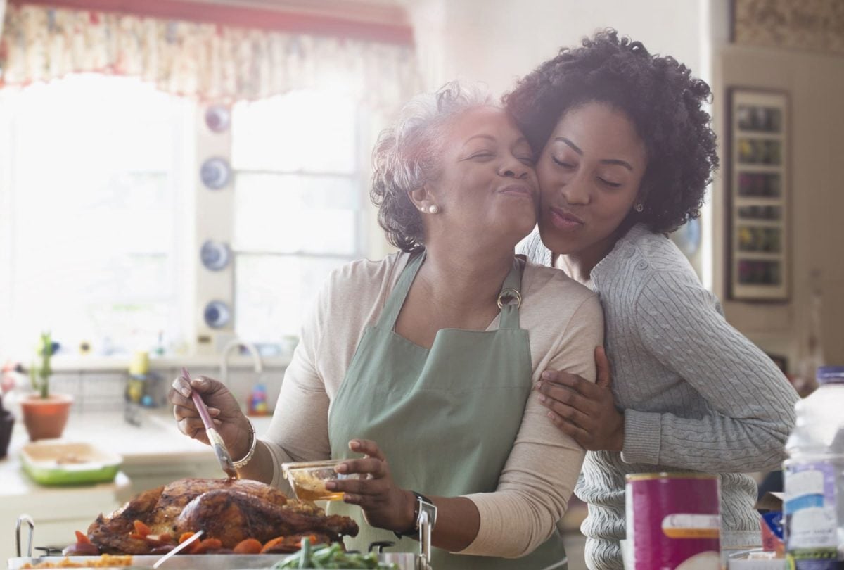 Mutter und Tochter stehen in der Küche und kochen zusammen.
