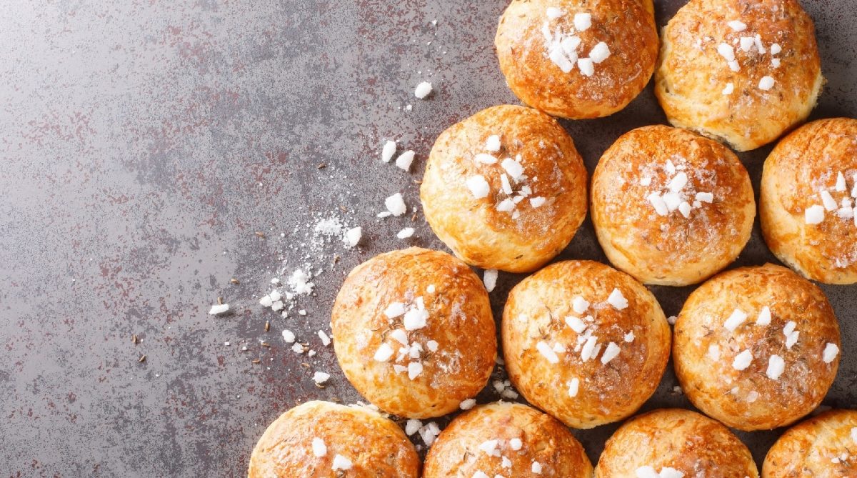 Englische Bath Buns mit Zuckerglasur auf grauem Beton-Hintergrund