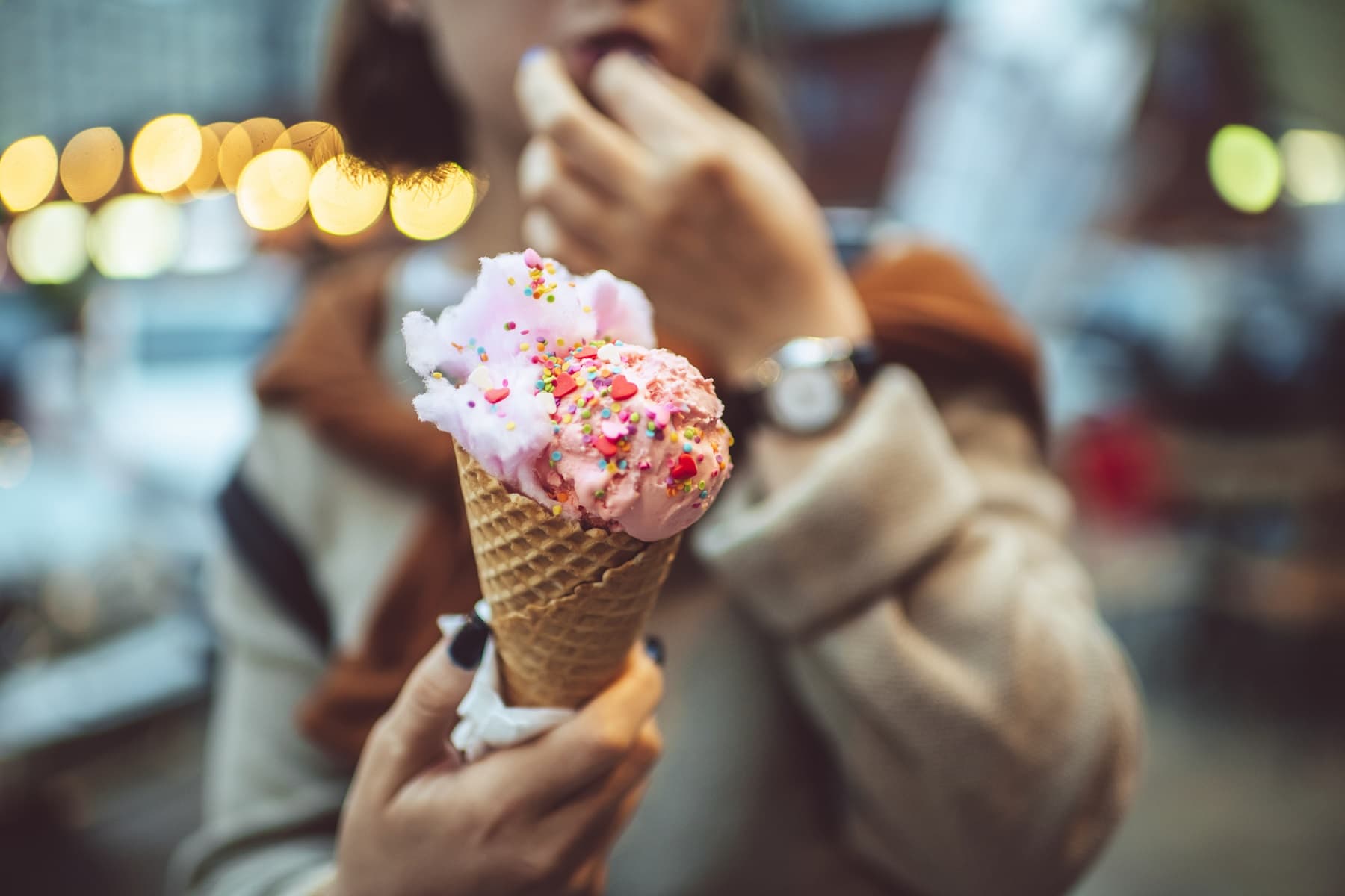 Berlin ICe Cream Week: Ein junges Mädchen hält eine Eiswaffel mit einer roten Kugel und Streuseln in die Kamera.