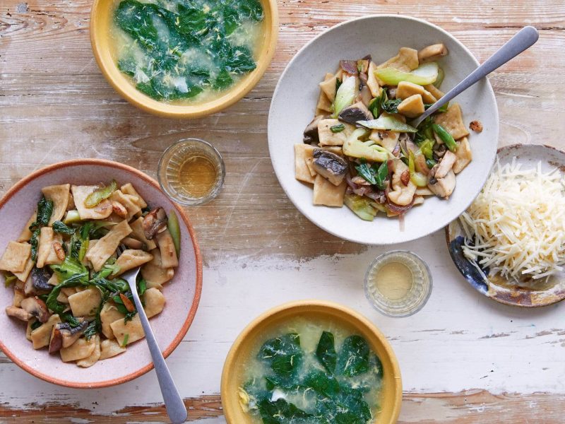 Brat-Thenthuk, handgezogene Nudeln mit Gemüse, und Brühe in Schüsseln in der Draufsicht. Das Rezept stammt aus dem Tibet-Kochbuch.