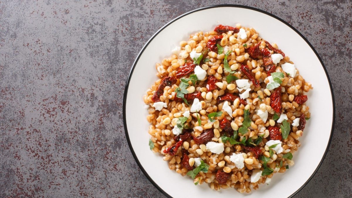 Farro Salat in einer weißen Schale auf grauem Untergrund.