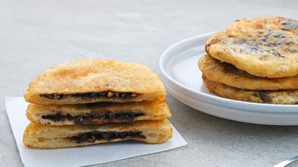 Mehrere koreanische Pfannkuchen auf einem grauen Untergrund und einem weißen Teller.