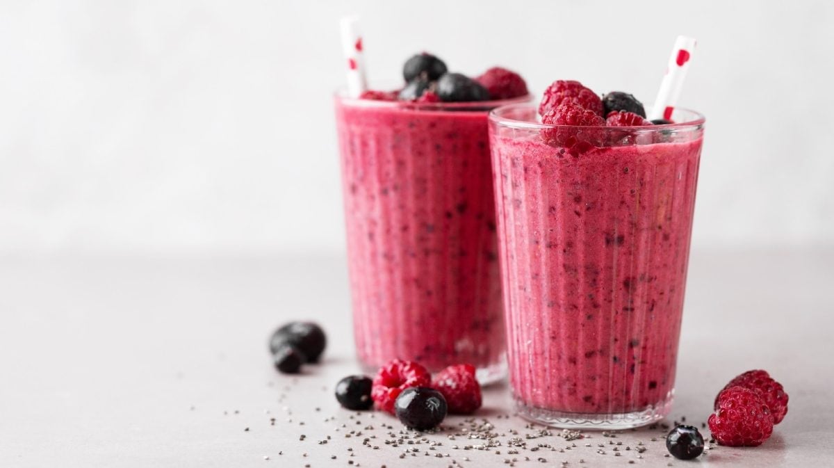 Kokos-Beeren-Shake mit Skyr in zwei Gläsern mit frischen Beeren