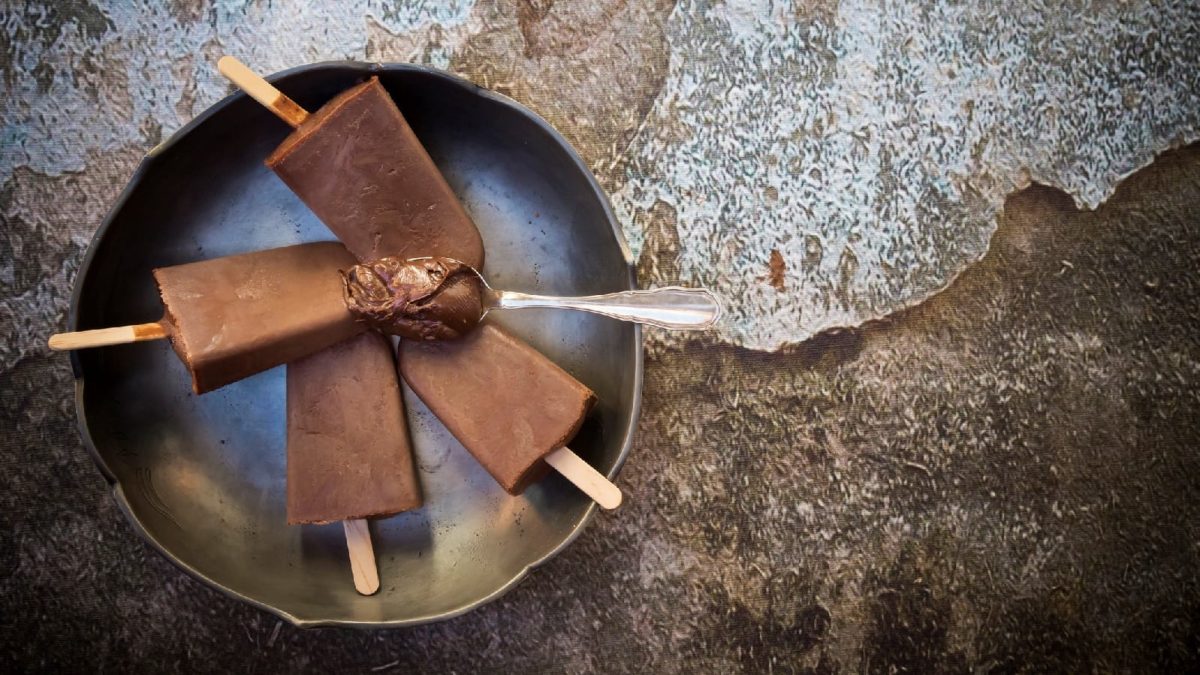 Nutella Popsicles mit einem Löffel Nutella auf einem Steinhintergrund