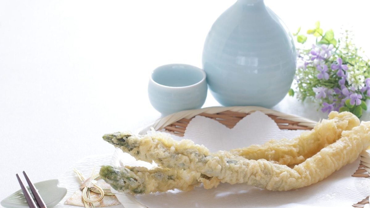 Auf einem Teller liegt Spargel-Tempura. Das sind frittierte Spargelstangen