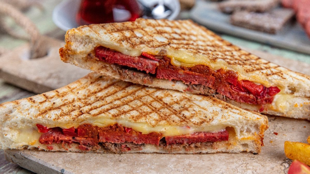 Zwei Scheiben des türkischen Toasts auf einem Holzbrett. und petrolblauem Untergrund.