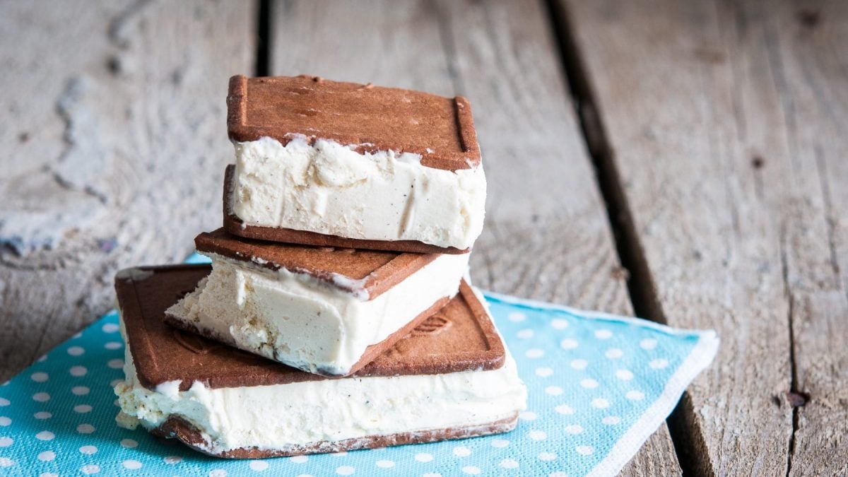 Drei vegane Milchschnitten gestapelt auf einer blauen Serviette auf rustikalem Holz.