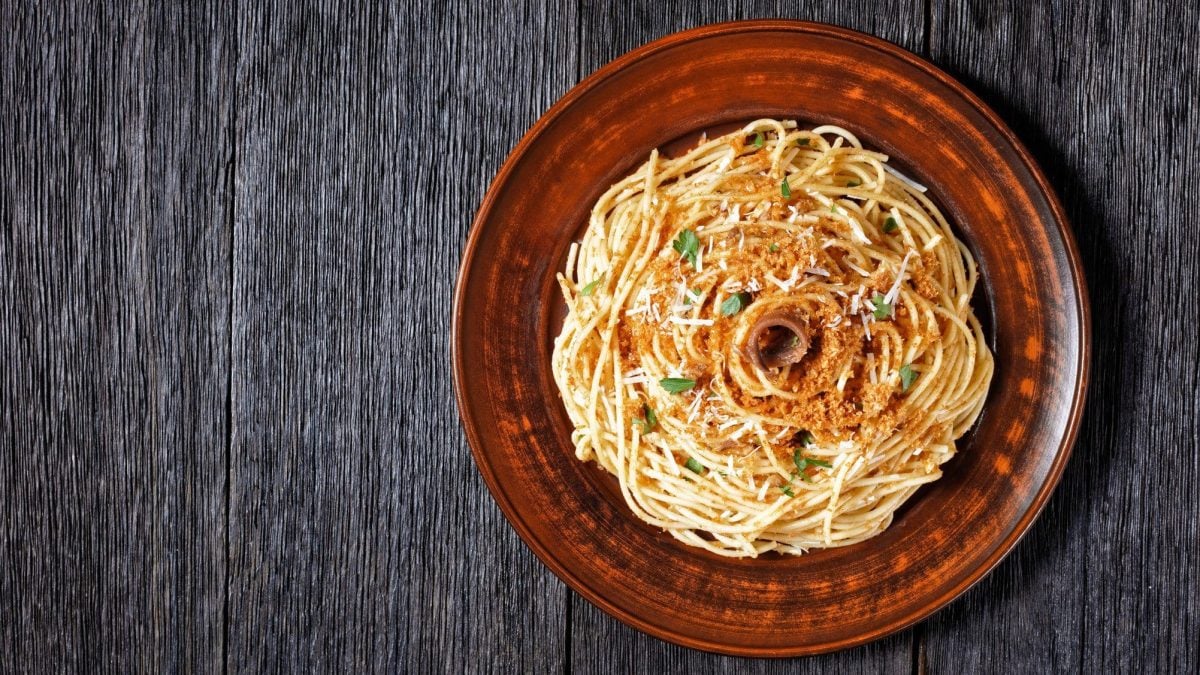 Pasta mollicata auf braunem Teller, angerichtet auf dunklem Holz.