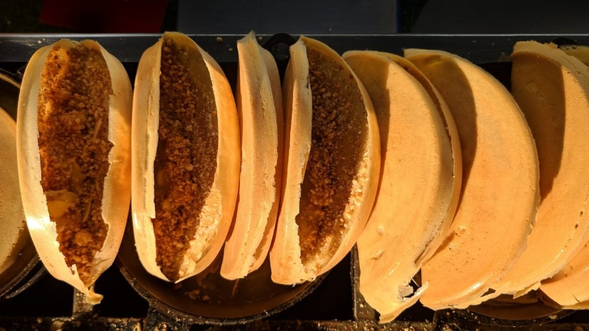 Mehrere Apam Balik aneinander gereiht an einem Streetfoodstand von oben fotografiert.