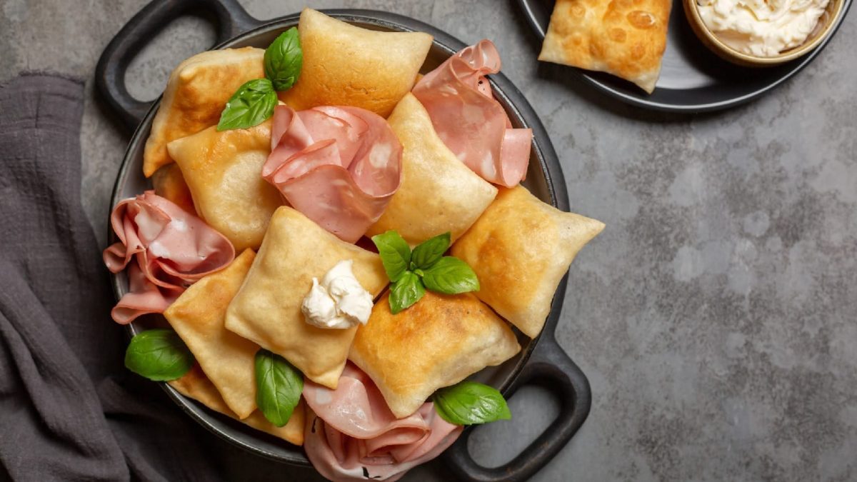 Ein schwarzer mit Teller Gnocco fritto auf grauem Hintergrund
