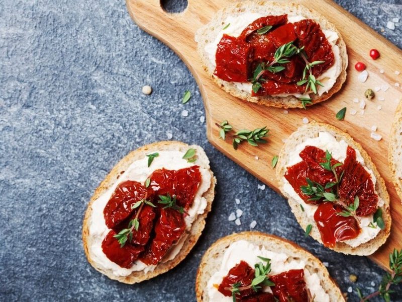 auf einem Holzbrettchen liegen mehre italienische Sandwiche mit Ricotta