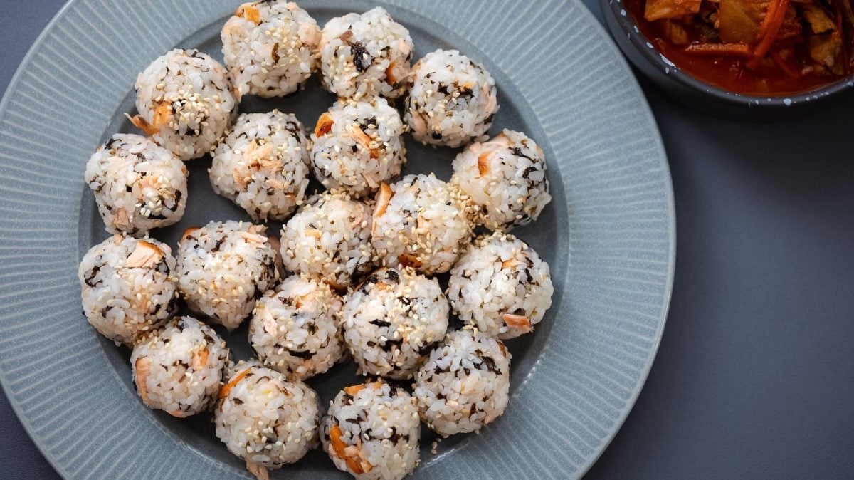 Jumeokbap, koreanische Reisbällchen, auf einem hellen runden Teller.