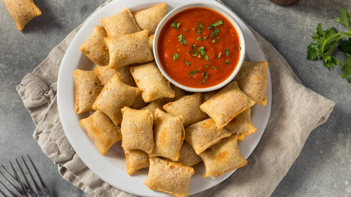 Pizza-Bites auf einem helgrauen Teller neben Marinara-Sauce