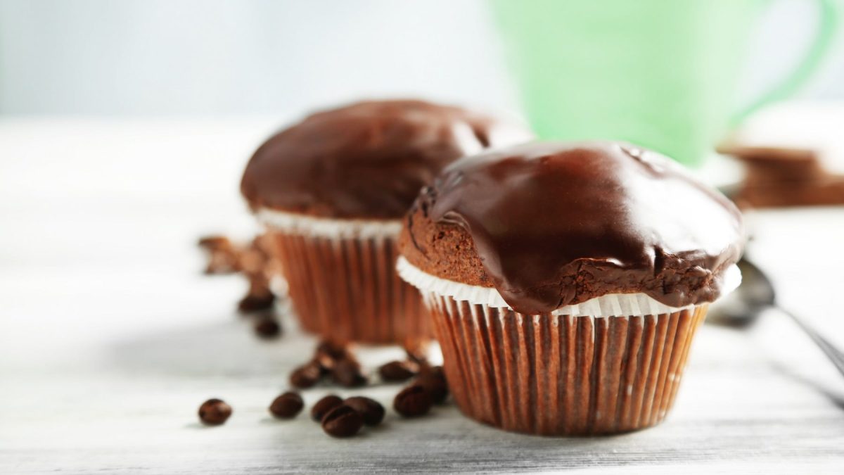 Zwei vegane Schokomuffins mit Karamellkern und Schokoladen-Ganache.
