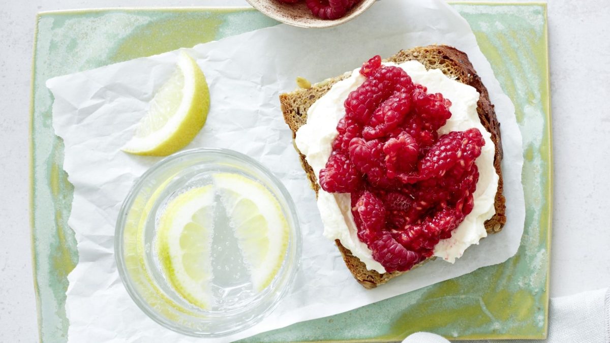 Himbeeren auf Brot auf einem gelben Tablett