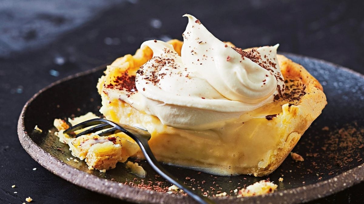 Auf einem Teller ist ein Pudding-Tortelett mit Baileys angerichtet. Es ist mit Schokoraspeln bedeckt.