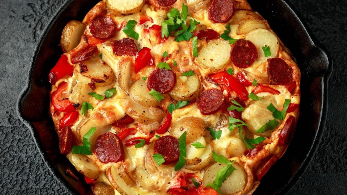 Frittata mit verschiedenen Tapas in gusseiserner Pfanne.