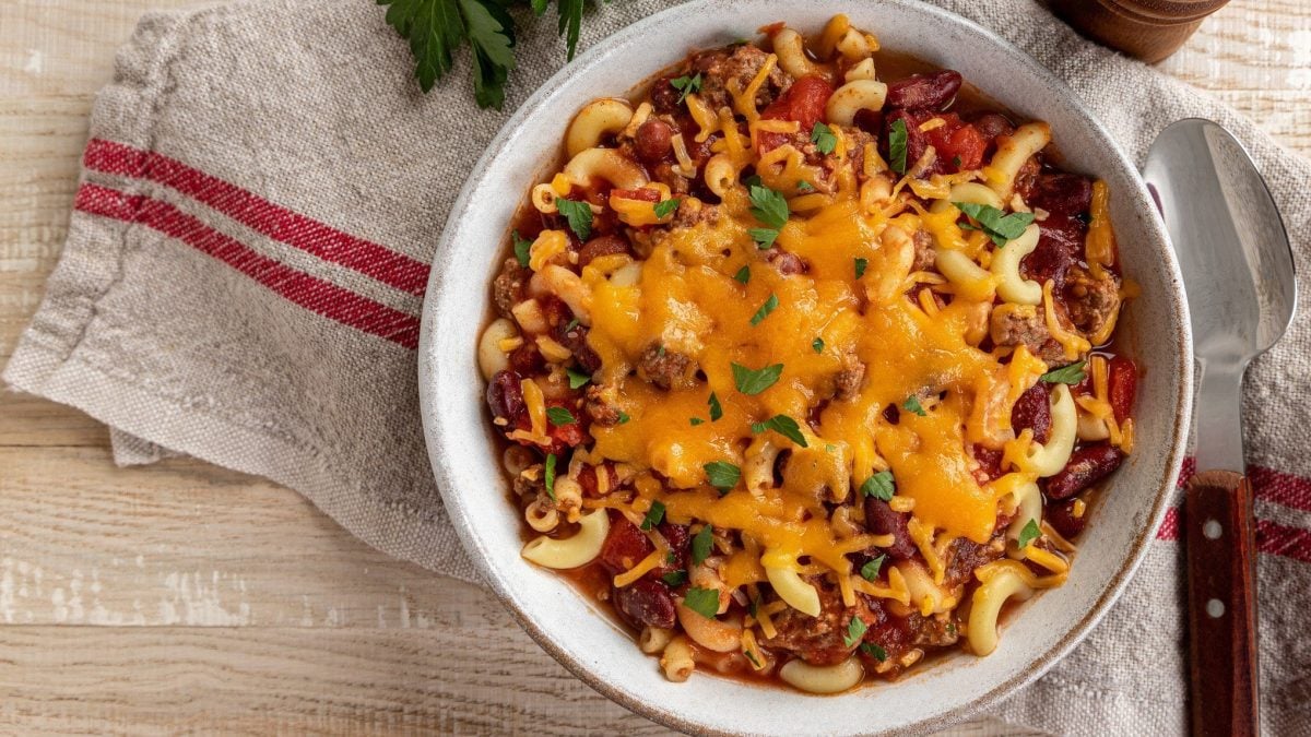 Chili-con-Carne-Pasta mit zerlaufenem Cheddar in weißer Schüssel.