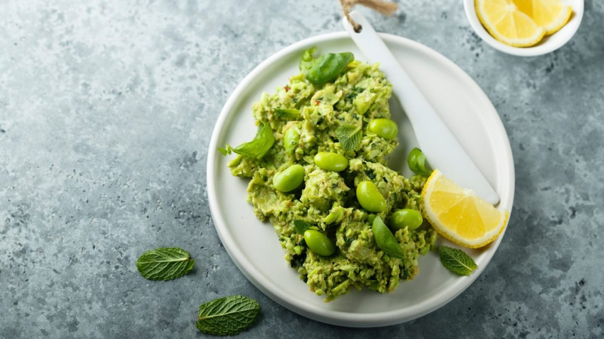 Ein Teller mit Edamame-Guacamole und Zitronenscheiben