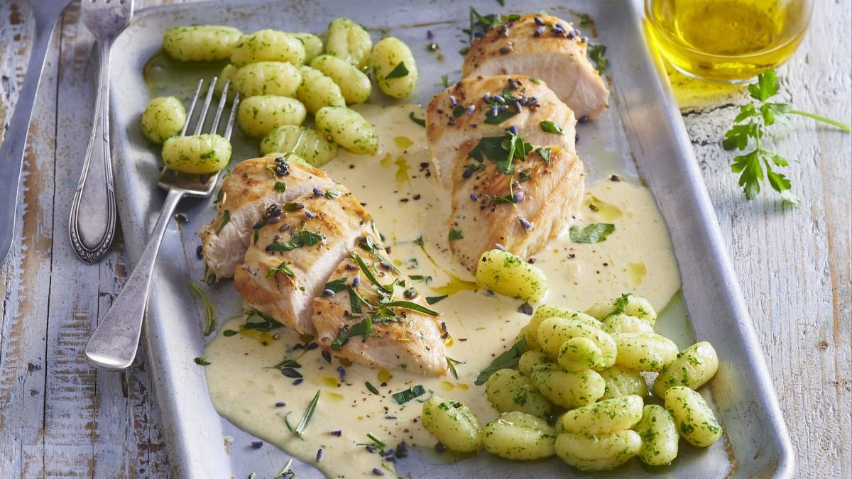 Hähnchenbrust mit Kräutern der Provence und Gnocchi auf einem Backblech.