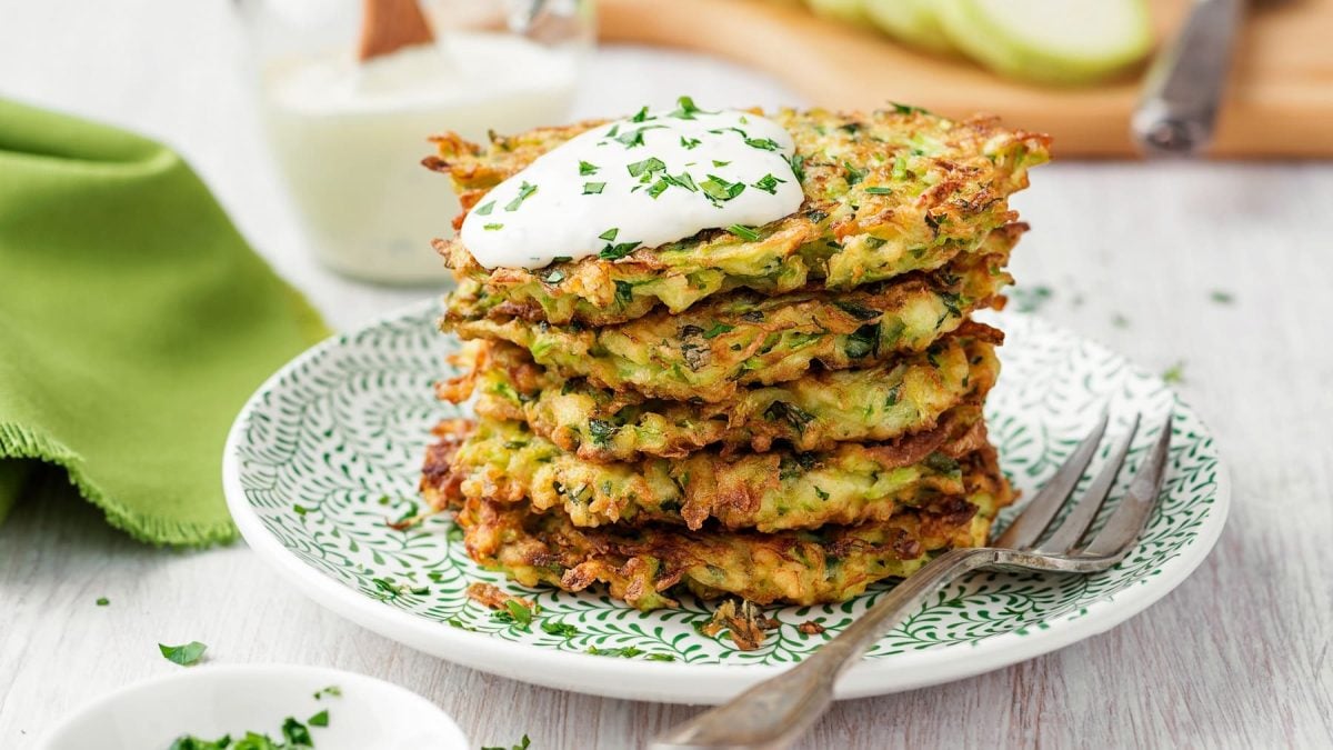 Ein Stapfel Kartoffelpuffer mit Mangold, darauf Quark.