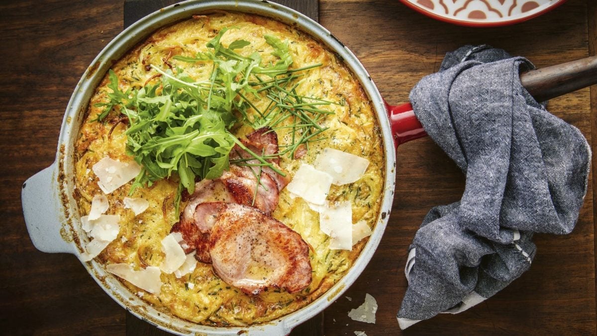 Frittata Spaghetti Carbonara in einer Pfanne vor Holzhintergrund