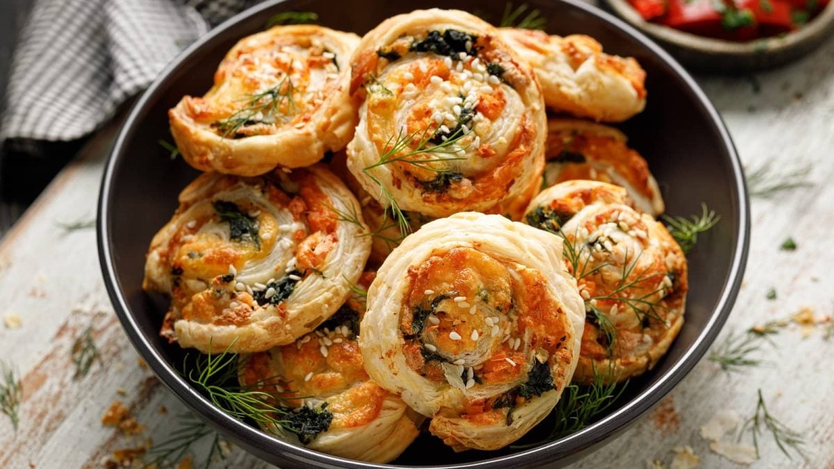 Gefüllte Blätterteig-Häppchen mit Lachs und Spinat in einem schwarzen Teller mit frischem Dill
