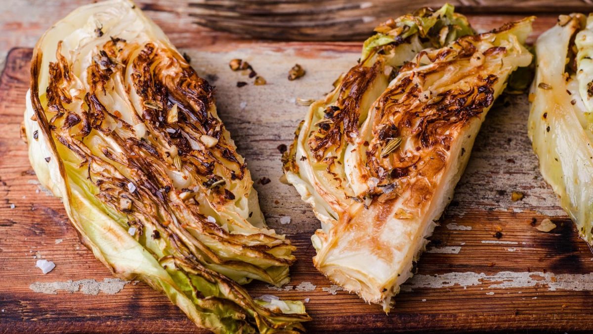 Gegrillter Spitzkohl mit Miso-Glasur auf Holz.