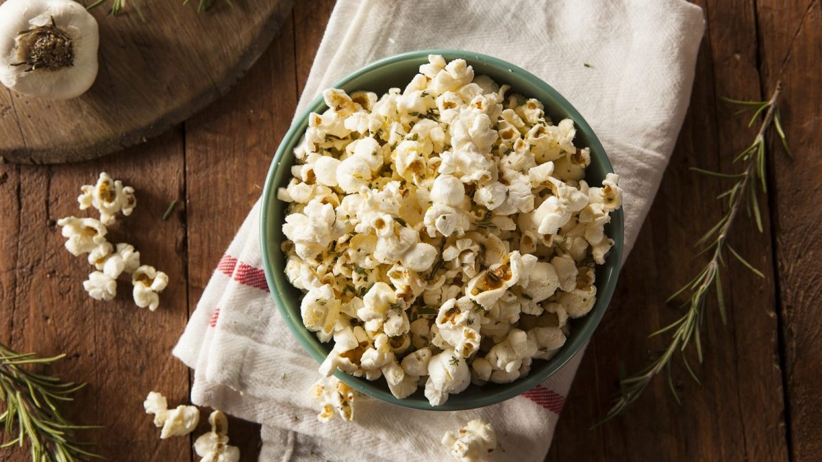Eine Schüssel mit Knoblauch-Popcorn auf einem weißen Geschirrtuch.